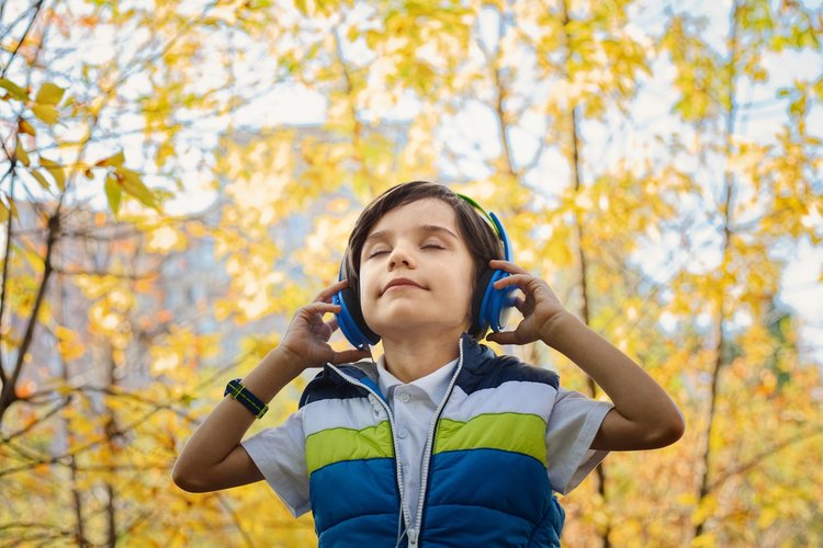 Young boy in a forest with headphones